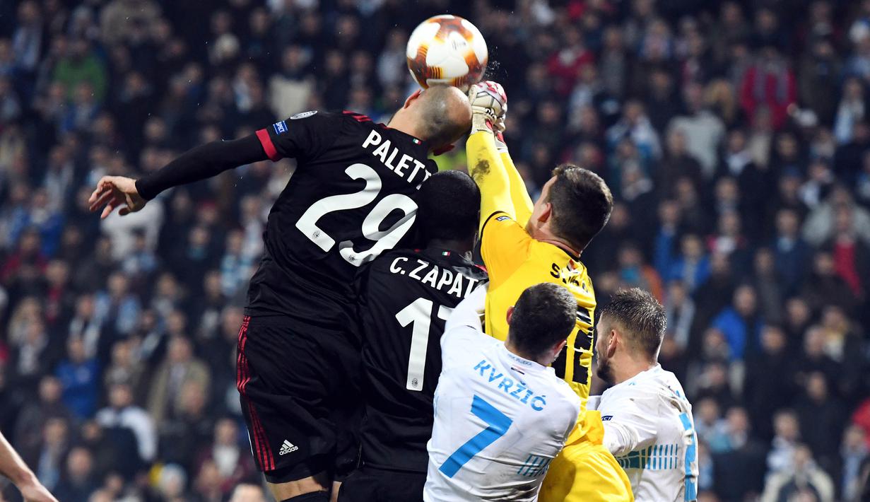 Gelandang AC Milan, Gabriel Paletta, duel udara dengan kiper Rijeka, Simon Sluga, pada laga Liga Europa di Stadion HNK Rijeka, Jumat (8/12/2017). AC Milan takluk 0-2 dari Rijeka. (AFP/Stringer)