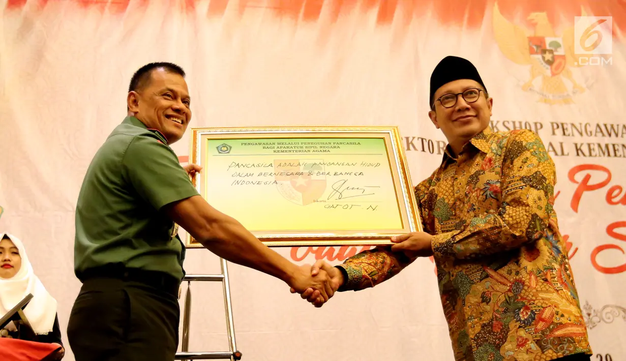 Panglima TNI Jenderal Gatot Nurmantyo menyerahkan tulisan tangannya tentang Pancasila kepada Menteri Agama Lukman Hakim Saifuddin pada acara Workshop Pengawasan Inspektorat Jenderal Kementerian Agama di Jakarta, Rabu (31/05). (Liputan6.com/Fery Pradolo)