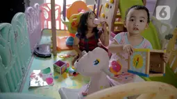 Dua orang anak bermain di dalam rumah di Kawasan Jakarta, Minggu (29/3/2020). Aktivitas bermain di dalam rumah saat ini menjadi alternatif warga dalam mengurangi interaksi sosial sebagai upaya pencegahan penyebaran virus corona atau COVID-19. (Liputan6.com/Faizal Fanani)