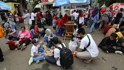 Pengunjung menikmati makan sambil lesehan jelang Closing Ceremony Asian Games 2018 di kawasan Gelora Bung Karno, Jakarta, Minggu (2/9). Mereka mengisi perut sebelum Closing Ceremony. (Liputan6.com/Fery Pradolo)