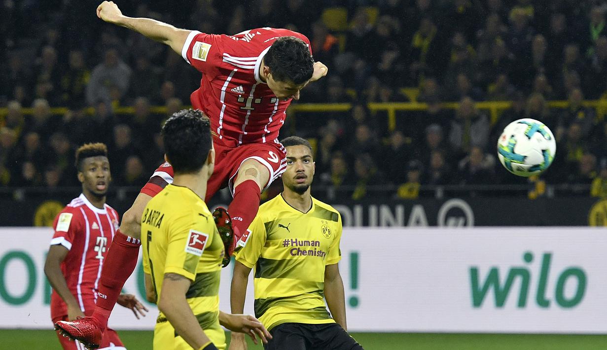 Pemain Bayern, Robert Lewandowski menyundul bola ke gawang Dortmund pada lanjutan Bundesliga di Signal Iduna Park, Dortmund, (4/11/2017). Bayern menang 3-1. (AP/Martin Meissner)