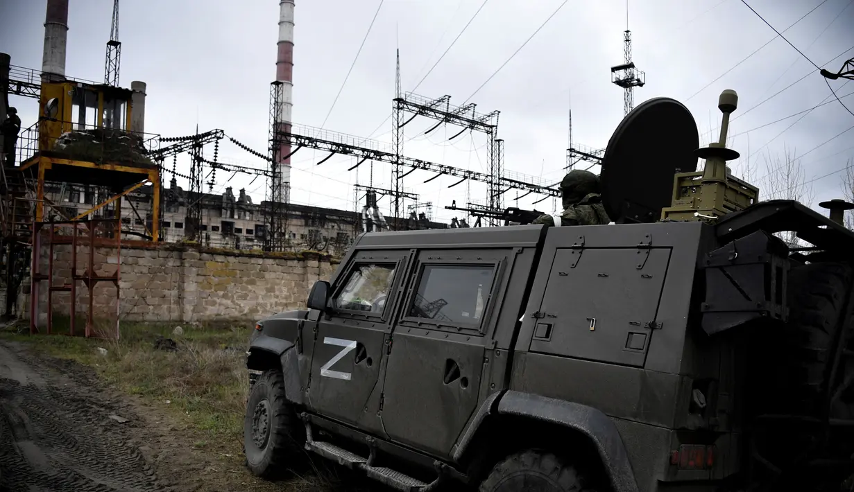 Tentara Rusia menjaga pembangkit listrik Luhansk di kota Shchastya (13/4/2022). Pabrik menghentikan pekerjaan pada 21 Februari 2022, kepala Administrasi Daerah Luhansk Serhiy Haidai menyatakan ini karena penembakan oleh pasukan separatis Rusia di Donbas. (AFP/Alexander Nemenov)