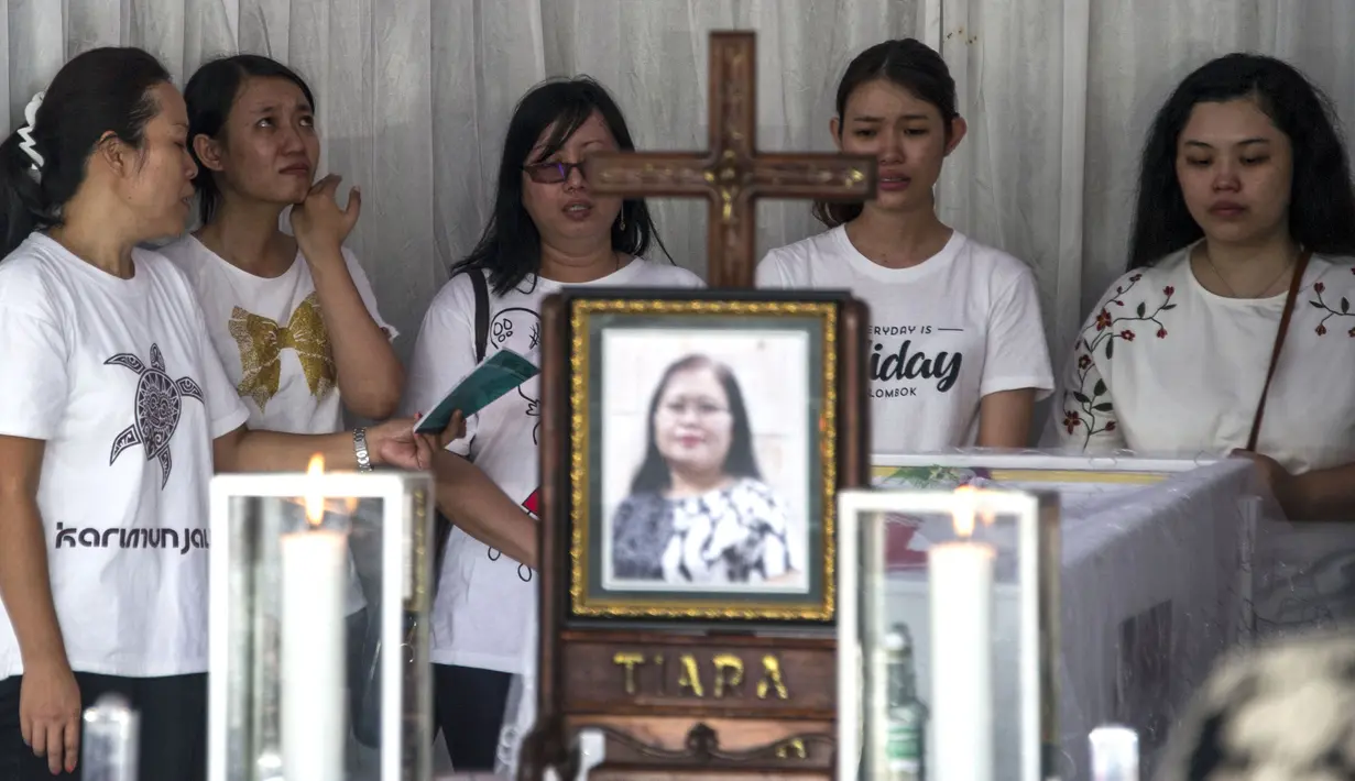 Tangis keluarga Martha Djumani, salah satu korban meninggal dalam serangan di Gereja Pantekosta, Surabaya, Jawa Timur, Senin (14/5). Bom bunuh diri menyerang tiga gereja di Surabaya pada Minggu, 13 Mei 2018. (AFP PHOTO/JUNI KRISWANTO)