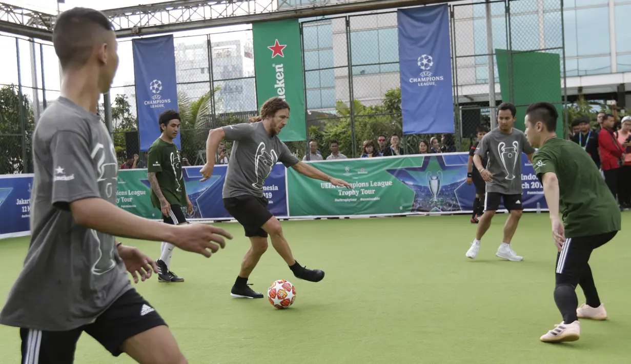 Legenda Barcelona, Carles Puyol, menggiring bola saat bermain futsal di Lapangan Menara Imperium, Jakarta, Selasa (12/3). Pertandingan tersebut merupakan bagian dari kegiatan UEFA Champions League Trophy Tour di Jakarta. (Bola.com/M Iqbal Ichsan)