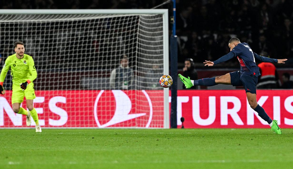 Pemain PSG, Kylian Mbappe (kanan) melesatkan tembakan ke gawang Real Sociedad yang dijaga Alex Remiro pada laga leg pertama 16 besar Liga Champions 2023/2024 di Parc des Princes, Paris, Prancis, Kamis (15/02/2024) WIB. (AFP/Miguel Medina)