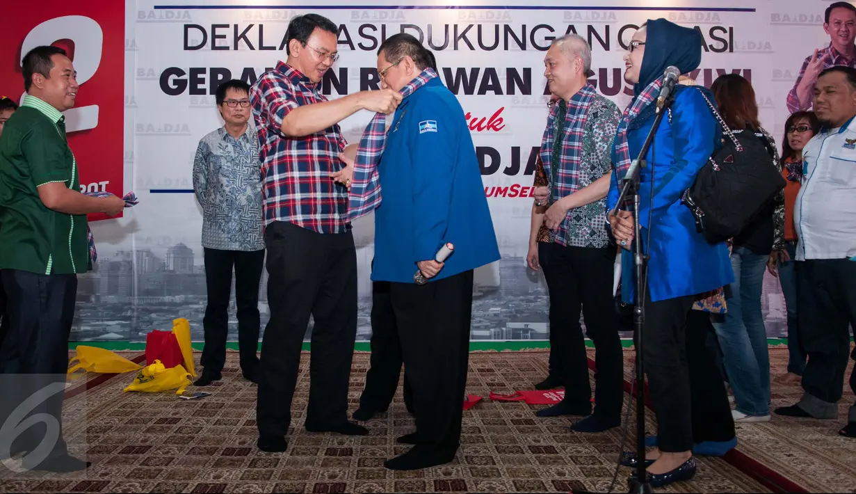 Basuki Tjahaja Purnama atau Ahok mengalungkan atribut kotak-kotak kepada perwakilan Gerakan Relawan Agus Harimurti Yudhoyono dan Sylviana Murni (Gerasi) saat acara deklarasi dukungan di Menteng, Jakarta Pusat, Senin (13/3). (Liputan6.com/Gempur M Surya)