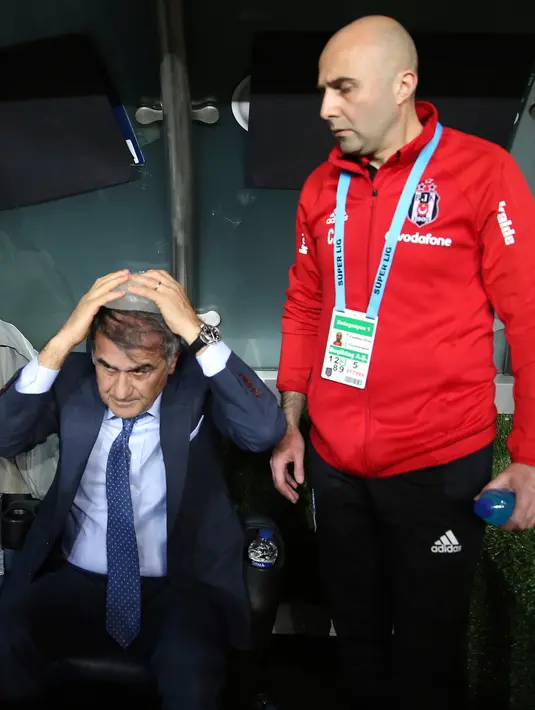 Pelatih Besiktas, Senol Gunes mengompres kepalanya setelah terkena lemparan benda tajam dari tribun penonton pada semifinal Piala Turki melawan Fenerbahce di Istanbul, Kamis (19/4). Pertandingan memanas usai pemain Besiktas, Pepe diganjar kartu merah (AP)