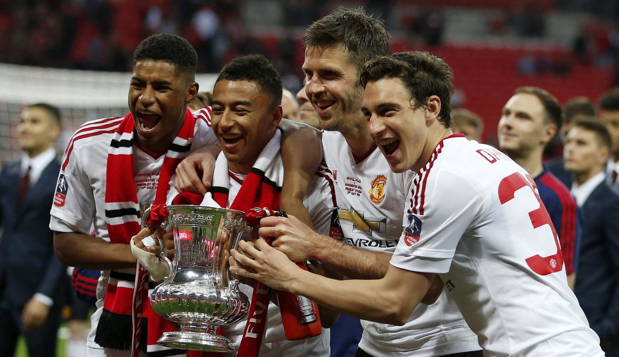 Para pemain Manchester United (dari kiri) Marcus Rashford, Jesse Lingard, Michael Carrick dan Matteo Darmian merayakan gelar Piala FA 2015/2016 setelah mengalahkan Crystal Palace pada laga final di Wembley Stadium, London (21/5/2016). Gelar Piala FA 2015/2016 menjadi trofi Piala FA terakhir yang diraih Manchester United setelah di partai final mengalahkan Crystal Palace dengan skor 2-1. (AFP/Ian Kington)