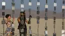 Denise S (kiri) dan Richard S. melihat pameran seni dalam festival festival Burning Man 2015 di Gurun Black Rock, Nevada, (31/9/2015). Partisipan dari seluruh dunia hadiri festival seni unik ini selama sepekan. (REUTERS/Jim Urquhart)