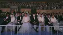 Sejumlah pasangan mengikuti kegiatan nikah massal di Cheong Shim Peace World Center di Gapyeong, Korea Selatan, Jumat, (7/2/2020). Meski memakai masker untuk mencegah virus corona, para pasangan pengantin tampak bahagia di acara tersebut. (AP Photo/Ahn Young-joon)