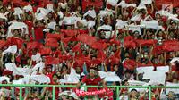 Suporter Indonesia menampilkan koreografi bendera Merah Putih jelang menyaksikan laga Indonesia lawan Laos pada penyisihan Grup A Sepak Bola Asian Games 2018 di Stadion Patriot Candrabhaga, Bekasi, Jumat (17/8). (Liputan6.com/Helmi Fithriansyah)