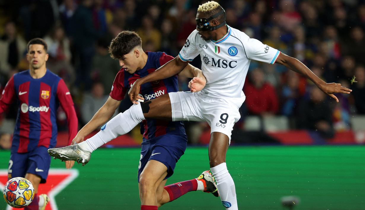 Pemain Barcelona, Pau Cubarsi (kiri) berebut bola dengan pemain Napoli, Victor Osimhen pada laga leg kedua babak 16 besar Liga Champions 2023/2024 di Estadio Olimpico Lluis Companys, Barcelona, Spanyol, Rabu (13/3/2024) dini hari WIB. Barcelona menang dengan skor 3-1 (agregat 4-2). (AFP/Lluis Gene)