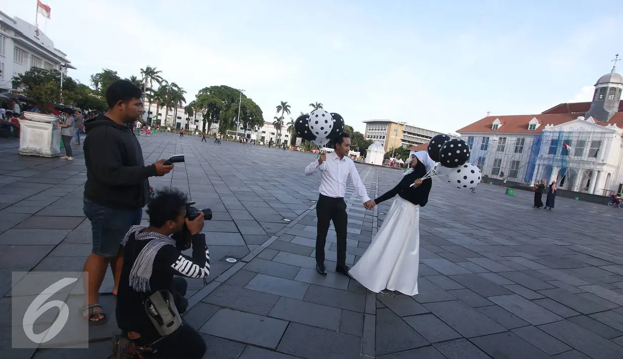 Fotografer mengabadikan foto untuk pranikah di kawasan Kota Tua, Jakarta, Kamis (29/9). Gubernur DKI Jakarta Basuki Tjahaja Purnama memastikan aktivitas foto pranikah di Kota Tua tidak dipungut biaya. (Liputan6.com/Immanuel Antonius)
