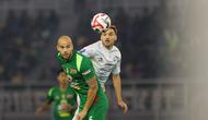 Pemain Persebaya, Risto Mitrevski berduel dengan pemain PSIM Yogyakarta, Nermin Haljeta pada pertandingan pembuka BRI Super League 2025/2026 di Stadion Gelora Bung Tomo, Jumat (08/08/2025) malam WIB. (Bola.com/Abdul Aziz)