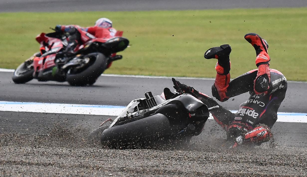 Pembalap dari tim Aprilia, Maverick Vinales terjatuh usai terpeleset ke luar lintasan pada balapan MotoGP Jepang 2023 di Sirkuit Motegi, Minggu (1/10/2023) siang WIB. (AFP/Toshifumi Kitamura)
