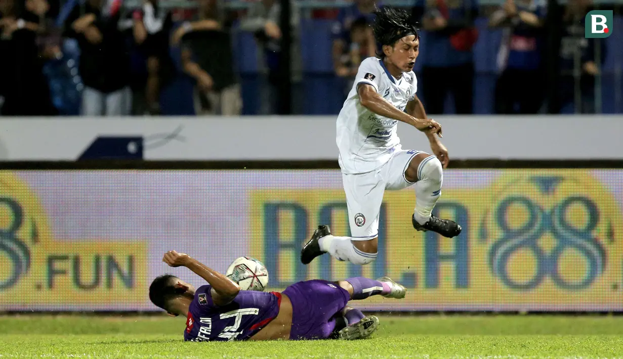 Pemain Persik Kediri, Mohammad Rifaldi (kiri) berebut bola dengan pemain Arema FC, Johan Ahmat Farizi dalam lanjutan pertandingan babak penyisihan Grup D Piala Presiden 2022 antara Persik Kediri menghadapi Arema FC di Stadion Kanjuruhan, Malang, Jawa Timur, Rabu (15/6/2022). (Bola.com/Arief Bagus)