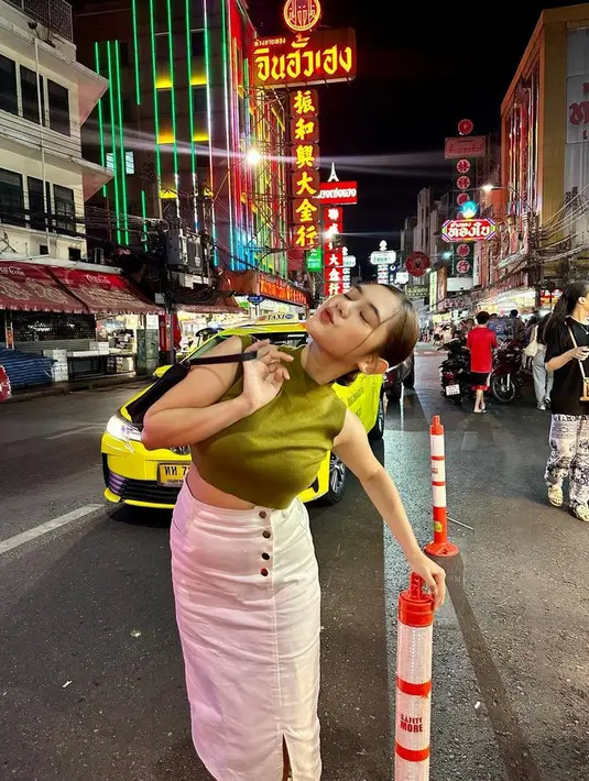 Ziva sedang dalam mood OOTD warna terang. Ia memadukan crop top sleeveless hijaunya dengan rok midi aksen kancing dan slit warna putih. [Foto: @zivamagnolya]