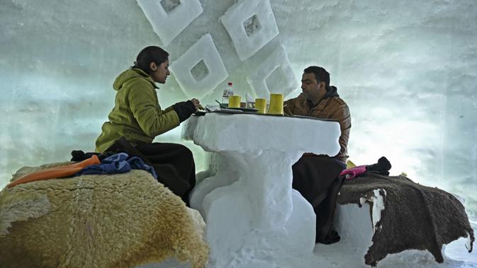Para tamu terlihat dalam Igloo yang terbuat dari salju di resor ski di Gulmarg, sekitar 55 km utara Srinagar, Jammu dan Kashmir, India, 25 Januari 2021. Meski terdengar begitu asing, Gulmarg termasuk salah satu dari tujuh destinasi permainan salju terbaik di dunia. (Tauseef MUSTAFA/AFP)