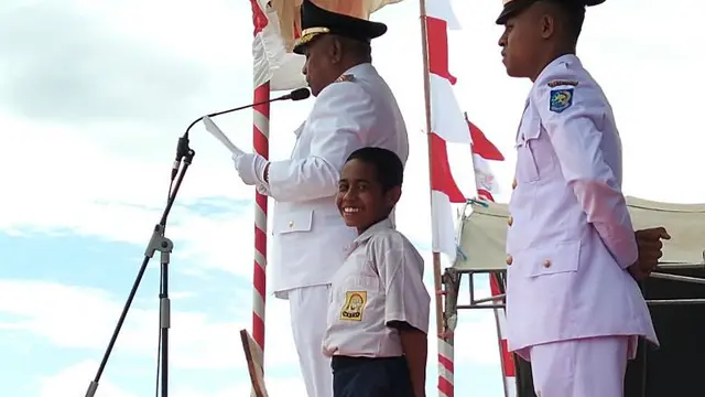 Joni, nama sapaannya, dengan berani memanjat tiang bendera akibat pengait bendera bermasalah. Video detik-detik Joni memanjat tiang bendera ini langsung viral di medsos (Twitter/@Kemlu_RI)