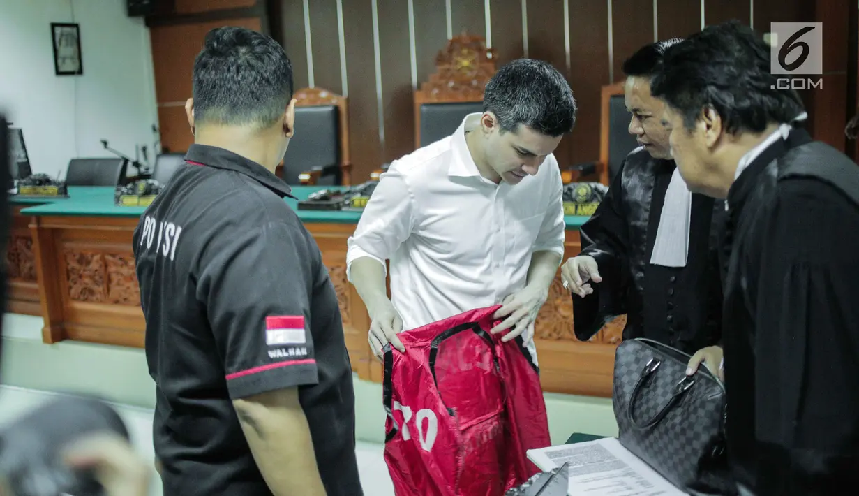 Artis Steve Emmanuel (tengah) mendengarkan kuasa hukumnya saat sidang putusan kasus narkoba di Pengadilan Negeri Jakarta Barat, Selasa (16/7/2019). Steve Emmanuel diganjar hukuman 9 tahun kurungan penjara dan denda Rp 1 miliar karena terbukti bersalah menyalahgunakan narkoba jenis kokain. (Liputan6.