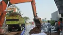 Alat berat menurunkan tanah untuk membuat tanggul di kawasan Perumahan Pantai Mutiara, Jakarta, (4/6). Tingginya pasang air laut menyebabkan tanggul di Jalan Mutiara 1, Pluit, Penjaringan, sepanjang sekitar 50 meter jebol. (Liputan6.com/Gempur M Surya)