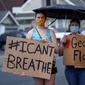 Sejumlah wanita memegang spanduk saat unjuk rasa atas kematian George Floyd oleh polisi di dekat TKP di Minneapolis, Minnesota, Amerika Serikat, Rabu (27/5/2020). Mayoritas demonstran hadir sambil membawa spanduk bertuliskan "I Can't Breathe" dan "Justice 4 Floyd". (Kerem Yucel/AFP)