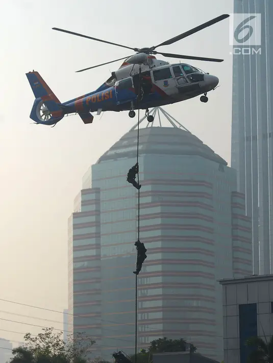 Petugas kepolisian menuruni helikopter menggunakan tali dalam apel pengamanan Asian Games 2018 di Lapangan Ditlantas Polda Metro Jaya, Jakarta, Selasa (31/7). (Merdeka.com/Imam Buhori)