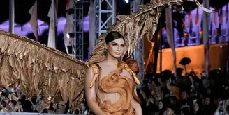 Jihane Almira Chedid adalah Puteri Indonesia Pariwisata 2020 dan Top 6 Miss Supranational, serta Miss Supranational Asia 2021. Juga dengan kostum yang tak kalah megah nan dramatis, Jihane Almira tampil dengan kostum bernuansa emas; dress dipenuhi bulu dan sayap besar berwarna emas. [Foto: Instagram/ourputeris]