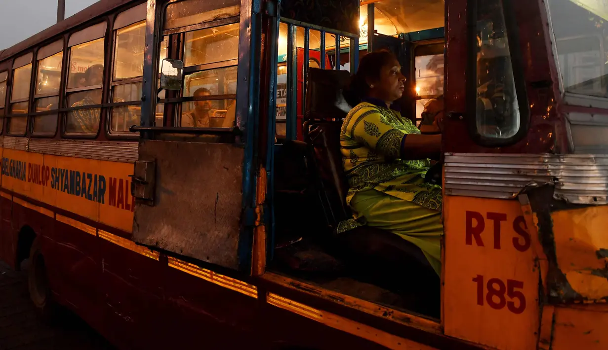 Pratima Poddar saat menunggu penumpang di Kolkata, India (8/3). Pratima Poddar 42 tahun merupakan satu-satunya sopir bus umum perempuan di Kolkata. (AFP Photo/Dibyangshu Sarkar)