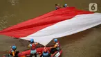 Sejumlah relawan membentangkan bendera Merah Putih di aliran kali
Ciliwung di kawasan Sudirman, Jakarta, Minggu (22/8/2021). Pembentangan atau pengibaran bendera Merah Putih tersebut dilaksanakan untuk memperingati HUT ke-76 RI. (Liputan6.com/Faizal Fanani)