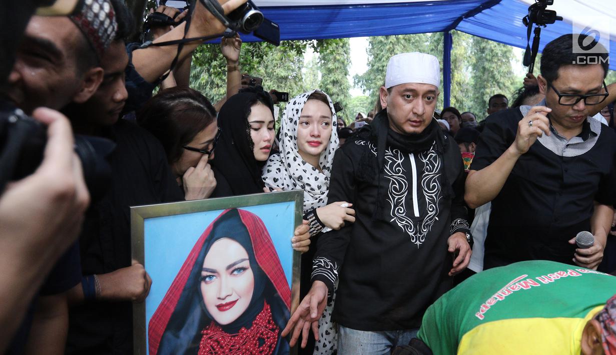 Penyanyi Ayu Ting Ting, Zaskia Gotik dan Ustaz Zacky Mirza menangis saat mengantar jenazah Julia Perez di TPU Pondok Ranggon, Jakarta Timur, Sabtu (10/6). Jupe diketahui mengidap sakit kanker serviks sejak 2014 silam. (Liputan6.com/Herman Zakharia)
