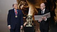 (Kiri/Kanan) Presiden AS, Donald Trump, memperhatikan saat menerima Hadiah Perdamaian FIFA (FIFA Peace Award) dari Presiden FIFA, Gianni Infantino, selama pengundian Piala Dunia 2026 yang berlangsung di AS, Kanada, dan Meksiko, di Kennedy Center, Washington, DC, pada 5 Desember 2025. (Brendan SMIALOWSKI/AFP)
