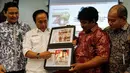 Direktur Filateli dan Properti PT Pos Indonesia, Tata Sugiarta (kiri) dan Ketua Panitia HUT PMI ke-70, Muhamad Muas (kedua kiri) menunjukan gambar perangko perayaan 70 tahun PMI di Museum Nasional, Jakarta,  Jumat (4/9/2015). (Liputan6.com/Yoppy Renato)