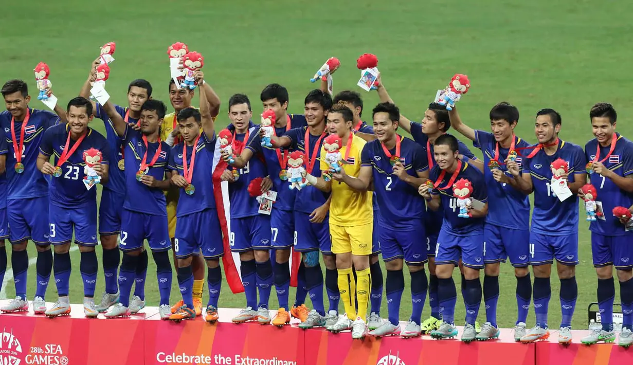 Pemain Thailand U-23 merayakan medali emas yang diraihnya setelah mengalahkan Myanmar U-23 dengan skor 3-0 dalam final sepak bola SEA Games 2015 di Stadion Nasional, Singapura. Senin (15/6). (Bola.com/Arief Bagus)