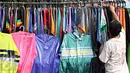 Seorang penjual jas hujan merapikan barang dagangannya di kawasan Jatinegara, Jakarta Timur, Rabu (11/11/2015). Memasuki musim hujan, penjualan jas hujan di kawasan tersebut mulai mengalami peningkatan. (Liputan6.com/Immanuel Antonius)
