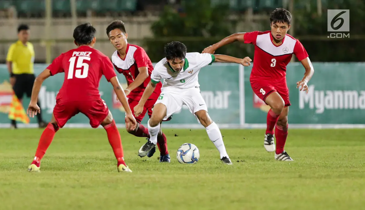 Pemain Timnas U-19 Indonesia Muhammad Iqbal menggiring bola dengan kawalan Timnas U-19 Filipina dalam laga kedua Grup B Piala AFF U-18 di Thuwunna Stadium, Myanmar, Kamis (8/9). Timnas U-19 Indonesia menang telak 9-0. (Liputan6.com/Yoppy Renato)