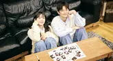 Dalam foto teaser, Seo In Guk dan Jung Eun Ji tampil dengan konsep yang sangat selaras dengan judul lagu, yaitu 'Couple'. Keduanya terlihat serasi mengenakan pakaian rajut dan celana jeans, duduk berdampingan di sofa sambil tersenyum hangat. (Liputan6.com/IG/@epmusic.official)
