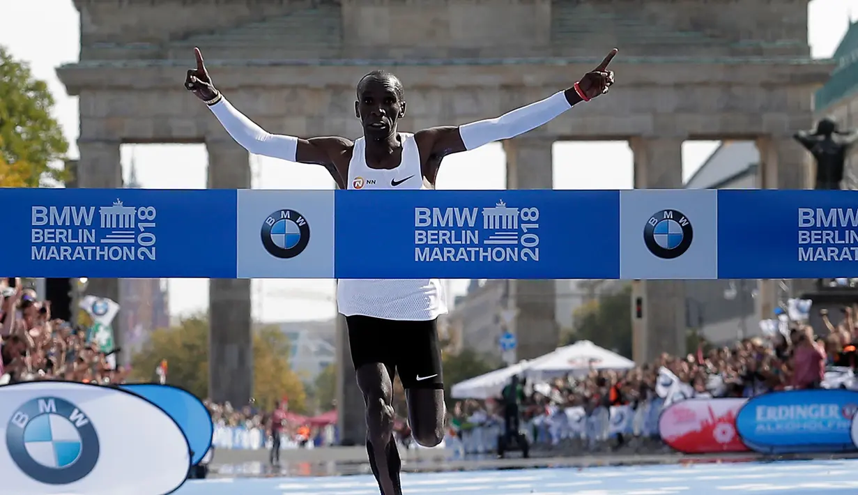 Pelari Kenya, Eliud Kipchoge tiba di garis finis Berlin Marathon ke-45 di Berlin, Jerman, Minggu (16/9). Kipchoge memangkas 1 menit 17 detik dari rekor dunia yang sebelumnya dipegang Dennis Kimetto di ajang lari yang sama. (AP Photo/Markus Schreiber)