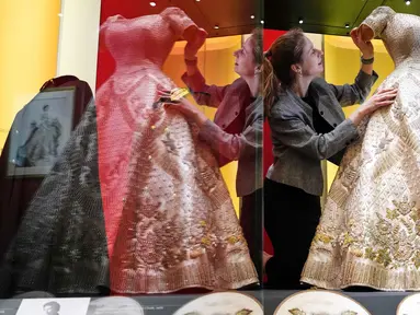 Cecilia Oliver, Konservator Tekstil di Royal Collection Trust, menyesuaikan gaun penobatan yang dikenakan oleh Ratu Elizabeth II, yang dipamerkan di pameran 'Queen Elizabeth II: Her Life in Style', di The King's Gallery, Istana Buckingham, London, Inggris, Kamis 9 April 2026. (AP Photo/Kirsty Wigglesworth)