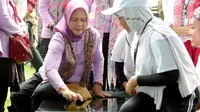 Iriana Jokowi saat menjajal permainan bekel di sela kunjungan ke Banyuwangi. (Hermawan/Liputan6.com)