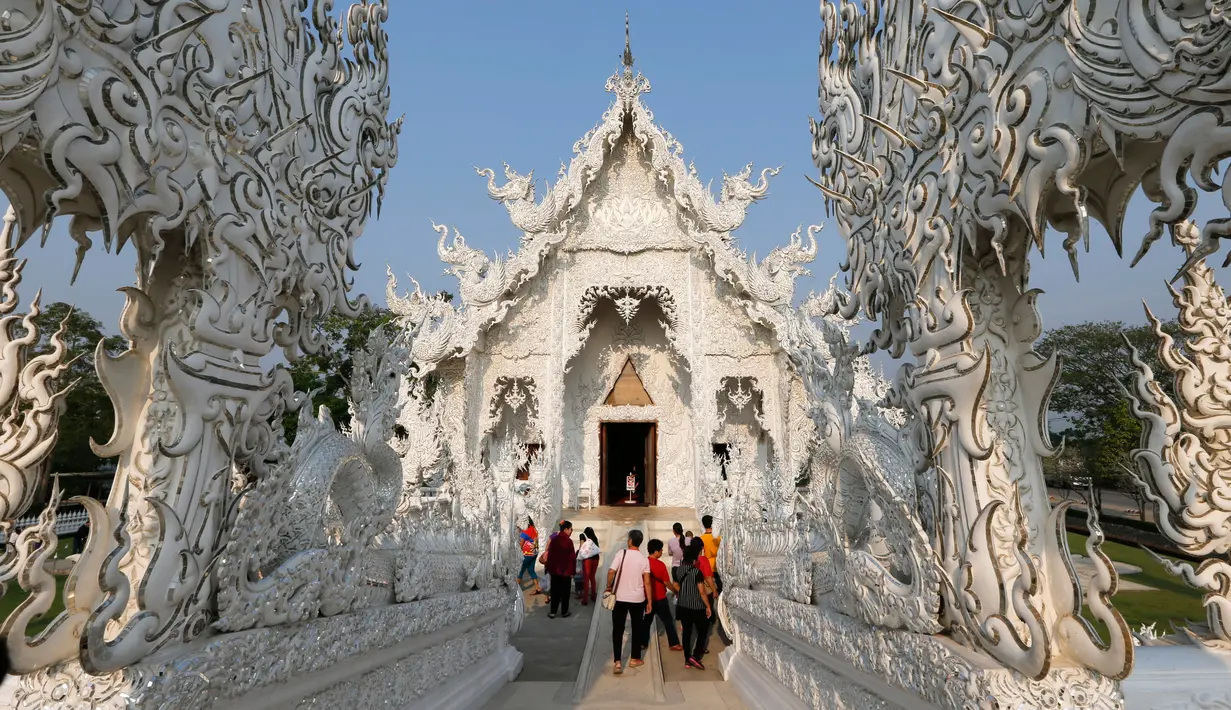 Sejumlah turis saat melakukan tur di Wat Rong Khun atau kuil putih di Provinsi Chiang Mai, Thailand, Jumat (4/3). Kuil Putih dirancang oleh seniman visual Thai Chalermchai Kositpipat. (REUTERS / Jorge Silva)