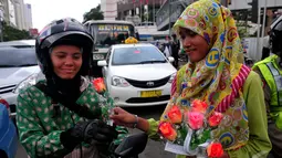 Pengendara sepeda motor saat mendapatkan bunga dari seorang mahasiswi dalam memperingati Hari Ibu,  Jakarta,Minggu (22/12/2014) (Liputan6.com/Johan Tallo)