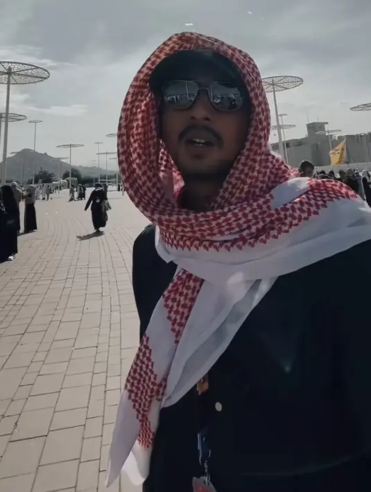 <p>Arya Saloka tampil dengan sorban merah di atas topi hitam cap. Dengan mengenakan gamis hitam dan kacamata. [@arya.saloka]</p>