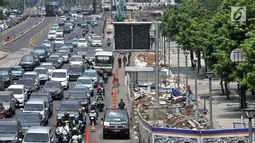 Kepadatan arus kendaraan saat melintas di depan proyek penataan ulang trotoar Jalan Jenderal Sudirman, Jakarta, Kamis (25/10). Proyek tersebut mempersempit jalur pejalan kaki dan menyebabkan kemacetan kendaraan. (Merdeka.com/Iqbal Nugroho)