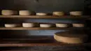 Deretan keju keras Swiss yang terbuat dari susu sapi mentah dan hanya diproduksi selama musim panas, disimpan rapi di ruang bawah tanah milik pembuat keju Cedric Maire. (Fabrice Coffrini/AFP)
