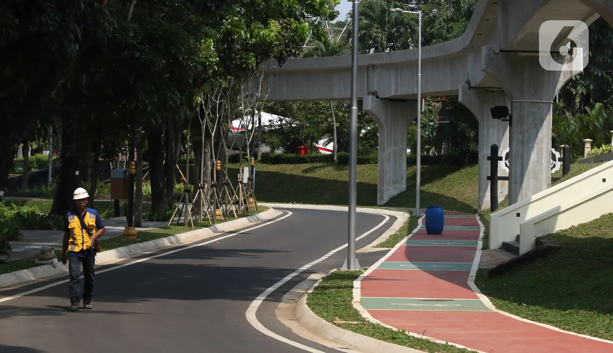 Pekerja melewati akses kendaraan di kawasan Taman Mini Indonesia Indah, Jakarta, Rabu (28/9/2022). Proses revitalisasi Taman Mini Indonesia Indah (TMII) itu telah mencapai 98 persen dan direncanakan akan menjadi salah satu lokasi KTT G20. (Liputan6.com/Herman Zakharia)