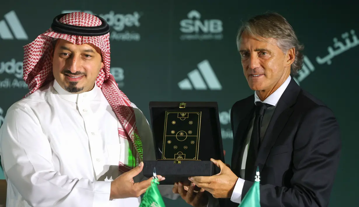 Roberto Mancini (kanan) melanjutkan kariernya di Timur Tengah dengan menjadi pelatih Timnas Arab Saudi. Mancini mendapatkan bayaran 30 juta euro per tahun dan menandatangani kontrak sampai tahun 2027. Alhasil, Mancini pun menjadi pelatih dengan bayaran termahal di dunia. (AFP/Fayez Nureldine)

Mancini .
