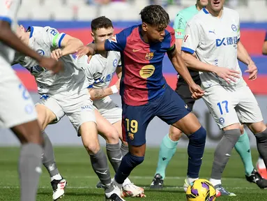 Pemain Barcelona, Lamine Yamal berusaha melewati penjagaan dari sejumlah pemain Deportivo Alaves dalam laga lanjutan Liga Spanyol 2024/2025 di Estadi Olimpic Lluis Companys, Barcelona, Spanyol, Minggu (02/02/2025) waktu setempat. (AFP/Josep Lago)
