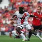 Gelandang Rayo Vallecano Pathe Ciss berduel dengan pemain&nbsp;Manchester United Christian Eriksen&nbsp;dalam pertandingan persahabatan di Old Trafford pada 31 Juli 2022. (foto: Nigel Roddis / AFP)