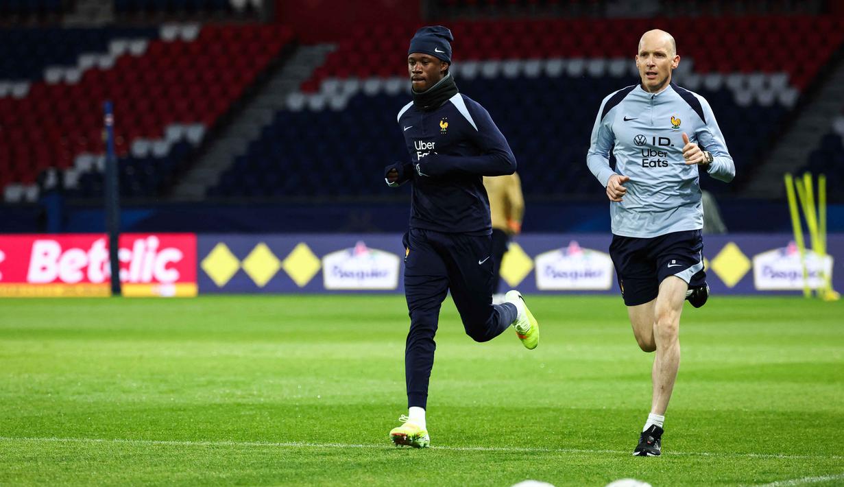 Diperkuat sederet nama besar seperti Kylian Mbappe, Ousmane Dembele, William Saliba, Michael Olise, dan Rayan Cherki, Les Blues siap menunjukkan dominasi mereka di Parc des Princes. Tampak dalam foto, gelandang Prancis, Eduardo Camavinga (kiri) berlari dan melakukan pemanasan di pinggir lapangan selama sesi latihan di Stadion Parc des Princes, Paris, pada Rabu 12 November 2025. (FRANCK FIFE/AFP)
